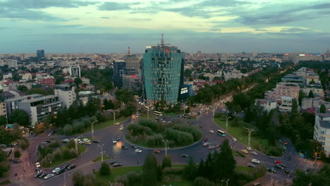 Charles-de-Gaulle-square-at-dusk-with-traffic-and-office-building-aerial-view,-Bucharest-Romania