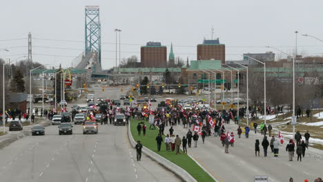 Freedom-convoy-protest-at-Road-Intersection,-people-come-and-go-holding-canadian-flags,-Time-Lapse