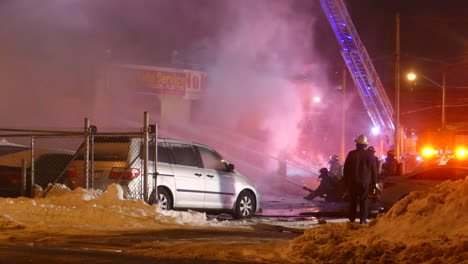 Firefighters-extinguishing-burning-building-in-Toronto,-night-time