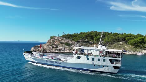 Car-ferry-leaving-Makarska-town-Croatia-Dalmatian-coast-drone-tracking