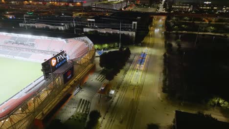 Luftaufnahme-Vorbei-Am-Pnc-stadion-In-Richtung-Der-Houston-Skyline,-Nachts-In-Texas,-Usa---Neigung,-Drohne-Erschossen
