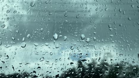 Water-drips-down-the-surface-of-a-glass-window-on-a-rainy-day