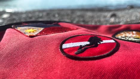 Rote-Tasche-Im-Eastpack-Stil-Mit-Tauchflaggenaufnäher,-Philippinischer-Flagge-Am-Meer