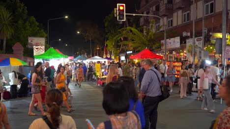 Foreigners-exploring-night-market-in-Chiang-Mai,-Thailand