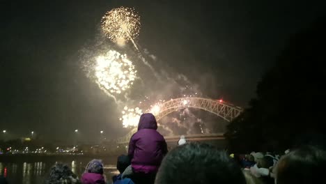 Crowd-watching-colourful-fireworks-sparkle-on-Silver-Jubilee-bridge,-Widnes