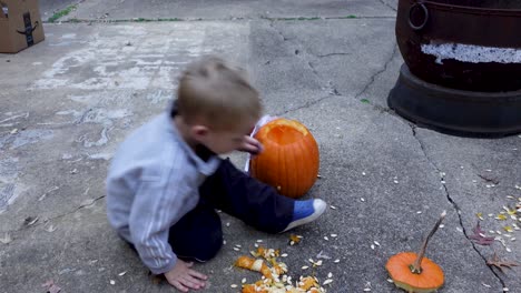 Beautiful-Blond-Boy-Carving-And-Decorating-Orange-pumpkin-At-Halloween-Time