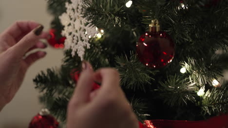 Neigen-Sie-Den-Weihnachtsbaum-Nach-Oben,-Während-Die-Hände-Die-Ornamente-Anpassen---Nahaufnahme