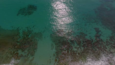 Drone-tilt-up-over-pristine-Amami-Beach-reveals-turquoise-ocean-and-reef
