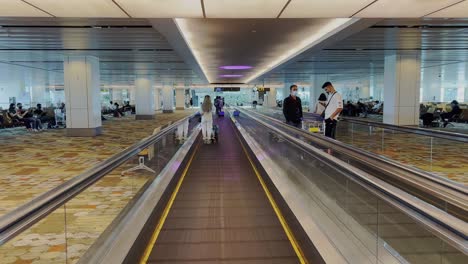 View-of-the-hall-and-the-moving-walkway-escalator-leading-to-the-gates-in-the-terminal-of-an-international-airport