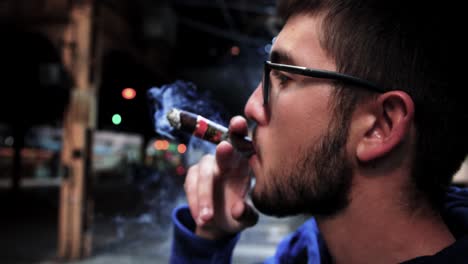 Young-adult-male-smoking-a-cigar-in-downtown-Chicago,-Illinois-in-slow-motion