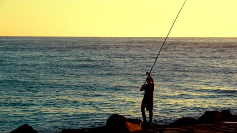 Silueta-Pescador-Pescando-En-La-Costa-Mar-Pescado-Fresco-épico-Atardecer-Fondo