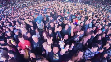 Spectators-Crowd-in-Front-of-Stage-Cheering-at-Rock-Music-Concert-Show,-Insta-360-Wide-Angle-View-of-Audience-Looking-Up-at-Camera-With-Sign-of-Horns-Hand-Gesture