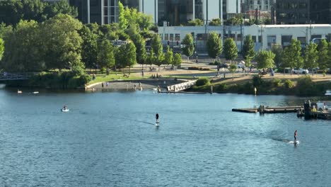People-riding-electric-surfboards-with-South-Lake-Union's-tech-headquarters-looming-in-the-backdrop
