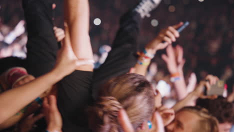 Fans-Enjoying-Partying-Inside-Arena,-Spectators-Crowd-in-Front-of-Stage-Cheering-Carrying-Young-Man-on-Arms-at-Rock-Music-Concert-Show,-Youth-and-Entertainment