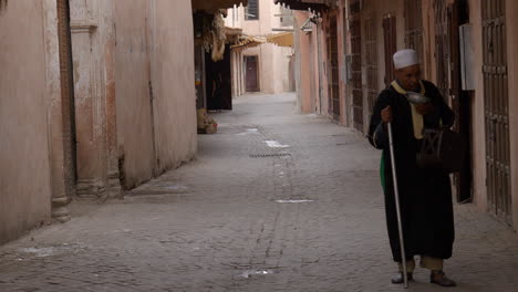 A-homeless-Muslim-beggar-walking-in-a-lonely-alley-at-Marrakesh,-Morocco
