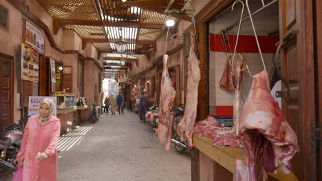 Typical-market-meat-shop-in-Marrakesh-street,-people-passing-by,-Morocco,-static