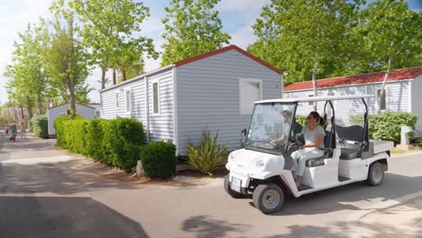 Couple-driving-a-golf-cart-through-the-small-camping-roads-in-France