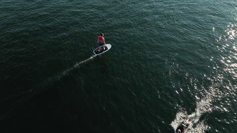 Drone-shot-of-someone-cruising-on-an-electric-surfboard