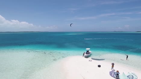 KITESURF-CAMP-IN-WHITE-SAND-BEACH-atoll-WITH-BOAT-AN-TWO-MEN-FLYING,-LOS-ROQUES