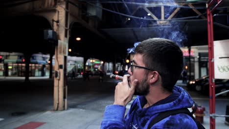 Macho-Adulto-Joven-Fumando-Un-Cigarro-En-El-Centro-De-Chicago,-Illinois
