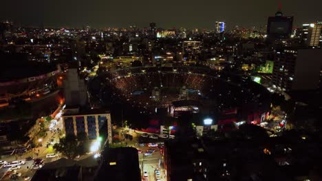 Aerial-view-of-the-Ciudad-de-los-deportes-Stadium,-during-Concert-night-in-Mexico-city---ascending,-tilt,-drone-shot