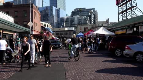 famous-Pike-Place-Market-Seattle-Washington-crowded-in-the-middle-of-the-day,-electric-bike-driving