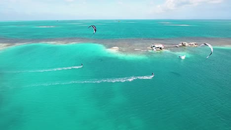 Luftbild-Zwei-Männer-Kitesurfen-Im-Paradies,-Archipel-Palafito-Los-Roques