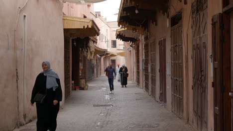 Few-Pedestrians-Walking-Along-The-Streets-With-Medieval-Structures-In-Marrakesh,-Morocco