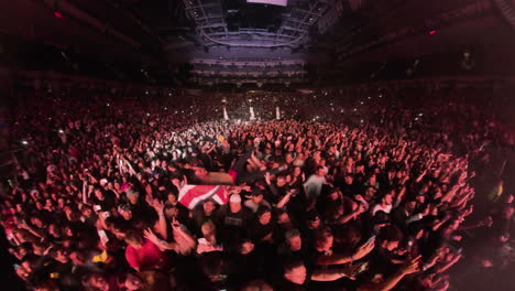 Insta-360-Wide-Angle-View-of-Mosh-Pit-Scene,-Spectators-Crowd-in-Front-of-Stage-Dancing-Cheering-Carrying-Man-on-Arms-at-Rock-Music-Concert-Show,-Arena-Panoramic-View-With-Colorful-Spotlights