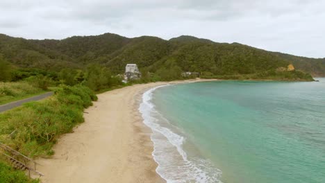 Drone-flight-along-sandy-coastline-of-tropical-Amami-Island,-Japan