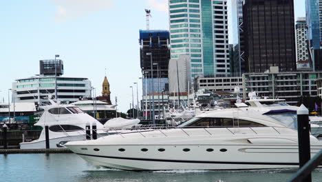 Luxury-yachts-leaving-port-of-Auckland-in-New-Zealand-with-cityscape-in-background