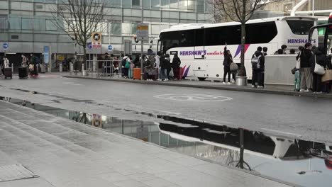 6-November-2022---Group-Of-Passengers-Leaving-Coach-At-Drop-Off-Point-At-Heathrow-Terminal-3-And-Crossing-Road-With-Their-Suitcases