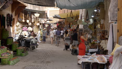 Touristen,-Die-Auf-Dem-Geschäftigen-Marktbasar-Von-Marrakesch-Stöbern-Und-Traditionelle-Souvenirs-Verkaufen