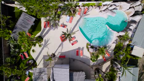 Top-down-aerial-over-a-swimming-pool-area-from-a-hotel