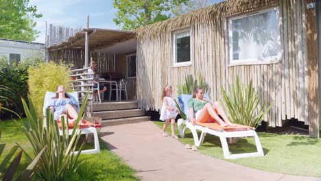 Family-enjoying-their-holiday-in-the-sun-in-front-of-thei-beautiful-bungalow-accommodation