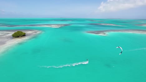 Aerial-view-tracking-MAN-KITESURF-TURQUOISE-Caribbean-SEA-WATER,-LOS-ROQUES-archipelago