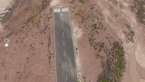 aerial-shot-of-small-airstrip-and-airplane-takeoff