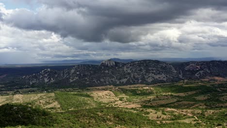 Trucking-left-aerial-drone-extreme-wide-shot-of-the-mountain-range-of-the-Pedra-de-Sao-Pedro-in-Sítio-Novo,-Brazil-in-the-state-of-Rio-Grande-do-Norte-during-a-overcast-stormy-summer-day