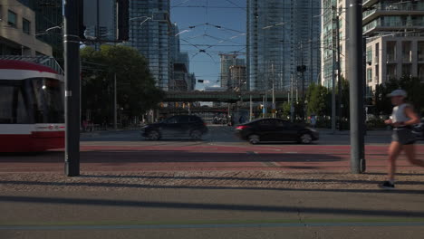 Exterior-wide-shot-of-a-red-TTC-streetcar-passing-through-frame