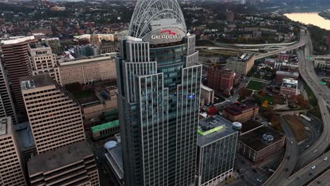 Aerial-view-approaching-the-Great-American-Tower,-sunrise-in-downtown-Cincinnati,-USA---rising,-tilt,-drone-shot