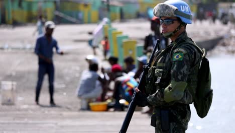 Bewaffneter-Brasilianischer-Soldat-Mit-Blauem-Un-helm,-Der-Den-Strand-Sichert