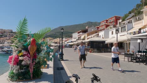 People-walking-along-the-promenade-of-Parga,-Greece