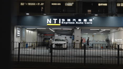 Vehículos-Y-Personas-Que-Pasan-Frente-A-Express-Auto-Care-Company,-Hongkong