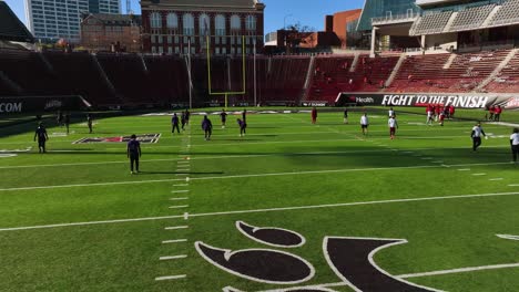 Aerial-view-of-the-Bearcats-training-inside-the-Nippert-Stadium,-in-Cincinnati,-USA---tracking,-drone-shot