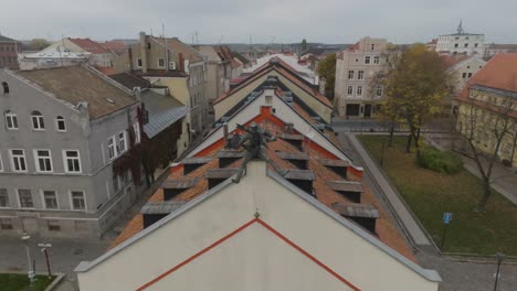 An-aerial-view-A-bronze-sculpture-of-a-happy-chimney-sweep-is-placed-on-the-edge-of-the-building's-roof-in-city-of-Klaipeda