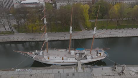 An-aerial-view-The-masted-sailing-ship-Meridian,-a-symbol-of-Klaipda,-is-moored-at-the-Danes-River-quays-in-Klaipeda-city