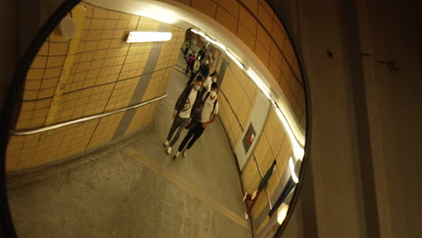 asiatic-pedestrian-walking-in-reflection-mirror-of-the-underground-of-metropolitan-area