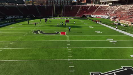 Aerial-view-of-a-Bearcats-team-practice-inside-the-Nippert-Stadium,-at-the-University-of-Cincinnati,-USA---reverse,-drone-shot