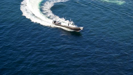 Police-boat-makes-a-turn-in-the-harbor-after-escorting-a-cruise-ship-away-from-port