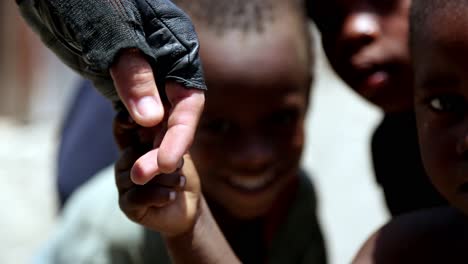 Soldier's-hand-with-tactical-gloves-hold-hand-with-local-children-in-Haiti